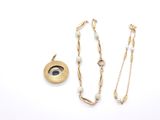 a close up of a necklace and earring on a white surface