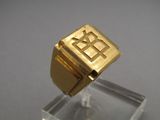 une bague en or avec la lettre « r » au milieu