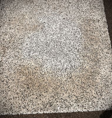 a white rug with black and white speckles on it