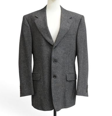 the suit is made of grey wool and has a black lapel