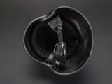 an old helmet with a leather strap on a black background