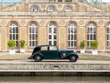 a vintage car parked in front of a large building