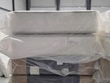 un gros tas de matelas dans un entrepôt