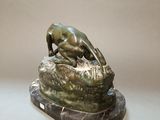 statue of a lion on a rock on a marble base