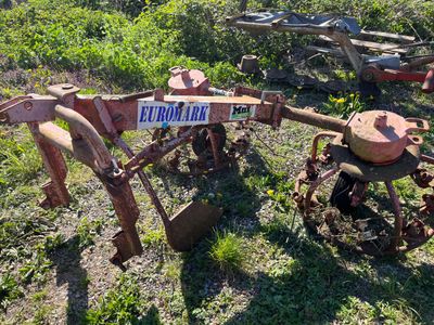 une charrue rouillée abandonnée au milieu d'un champ