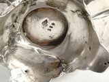 a close up of a silver plate with a bird on it