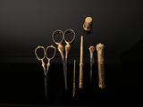 five pairs of scissors that are on display in a dark room
