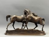sculpture en bronze représentant deux chevaux, posée sur un socle en bois, sur fond gris