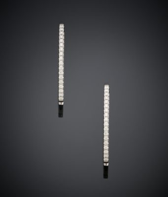 une paire de boucles d'oreilles créoles en diamant sur un fond sombre