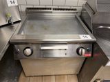 a stainless steel stove top in a kitchen with a sink