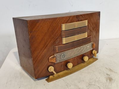 une radio à l'ancienne posée sur une table blanche