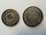 two silver coins with a picture of a man and a woman on them