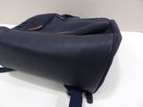 navy blue leather handbag on a white table with a blue strap