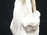 a white statue of a woman with a basket on her head