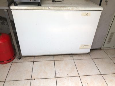 a small white refrigerator in the corner of a kitchen