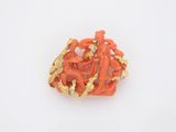 une broche orange et dorée ornée de personnages