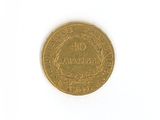 a close up of a gold coin on a white surface