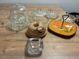 a wooden table topped with glass dishes and dishes