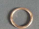 a gold ring that is on a gray cloth