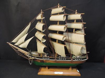 a model of a sailboat on a wooden stand