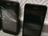 three cell phones are sitting next to each other on the floor