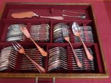 de nombreuses cuillères et fourchettes dans une boîte posée sur une table
