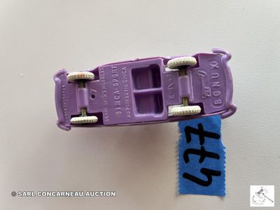 une petite voiture violette posée sur une feuille de papier