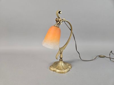 lampe de table en laiton avec un abat-jour en verre orange sur fond blanc