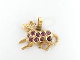 a close up of a gold pendant with a mouse on it