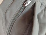 the zipper on the bottom of a pair of grey pants