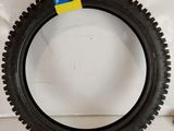 a close up of a tire on a white surface with a yellow tag