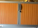 a metal cabinet with a sliding door on top of it