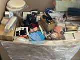 une grande boîte remplie d'objets divers, posée par terre