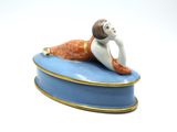 a figurine of a woman laying on a blue box
