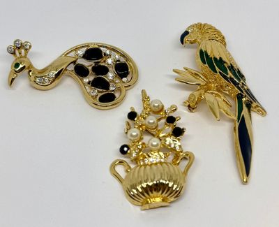 Deux broches de formes et de couleurs différentes sont posées sur une surface blanche