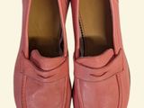 pair of pink loafers on a white surface with a white background