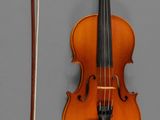 a violin and a bow on a gray surface