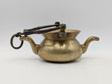an old brass teapot with a handle on a white background
