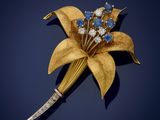 an image of a gold and blue flower broochle on a blue background