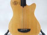 a close up of a bass guitar on a stand against a white background