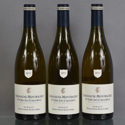 three bottles of white wine are lined up on a table