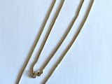 Collier à chaîne en plaqué or avec fermoir, sur fond blanc