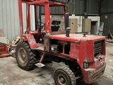 un chariot élévateur rouge garé dans un entrepôt