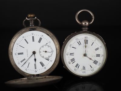 deux horloges posées côte à côte sur une surface noire