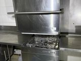 a large stainless steel stove in a kitchen with a basket in front of it