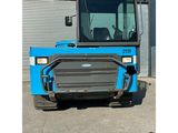 a close up of a blue tractor parked in front of a building