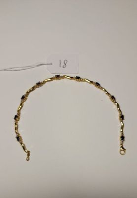 a close up of a gold bracelet on a white surface