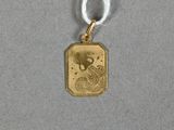un gros plan d'un pendentif plaqué or orné d'un dragon