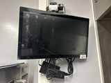 a flat screen tv mounted on a wall in a kitchen