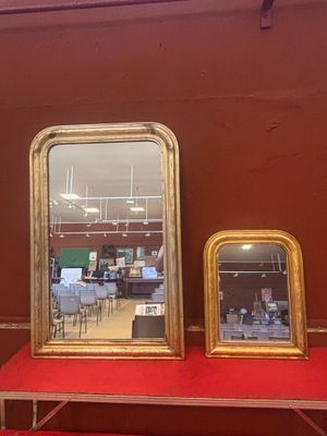 trois miroirs posés sur une table rouge dans une pièce